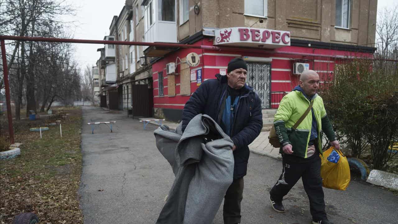 Men carry their possessions during evacuation from Pokrovsk