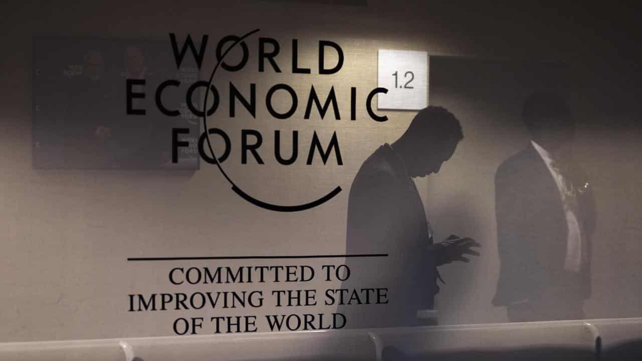 Men reflected in a panel with the WEF logo, Davos, Switzerland