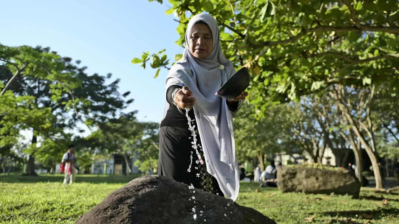 A woman at a mass grave of victims of the 2004 tsunami in Banda Aceh