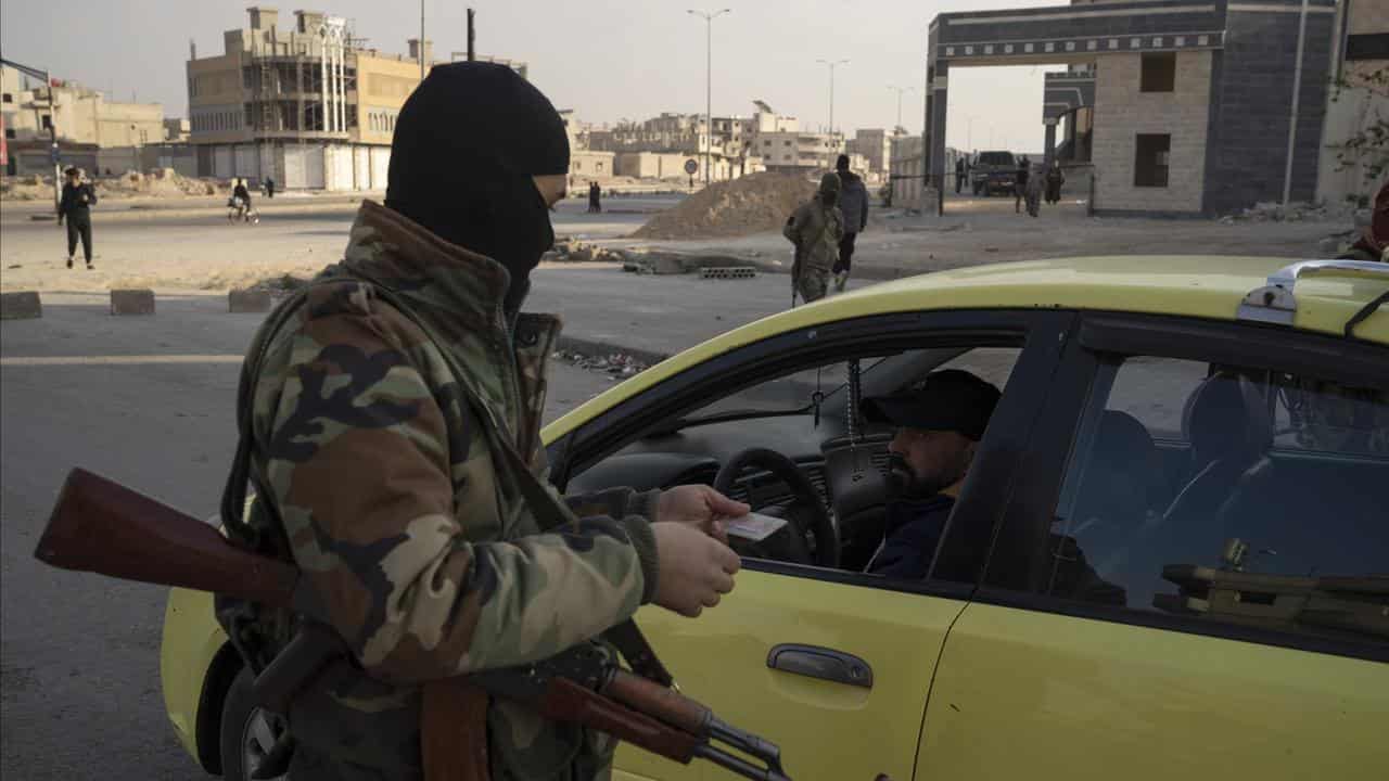 Security forces checks the ID of a driver