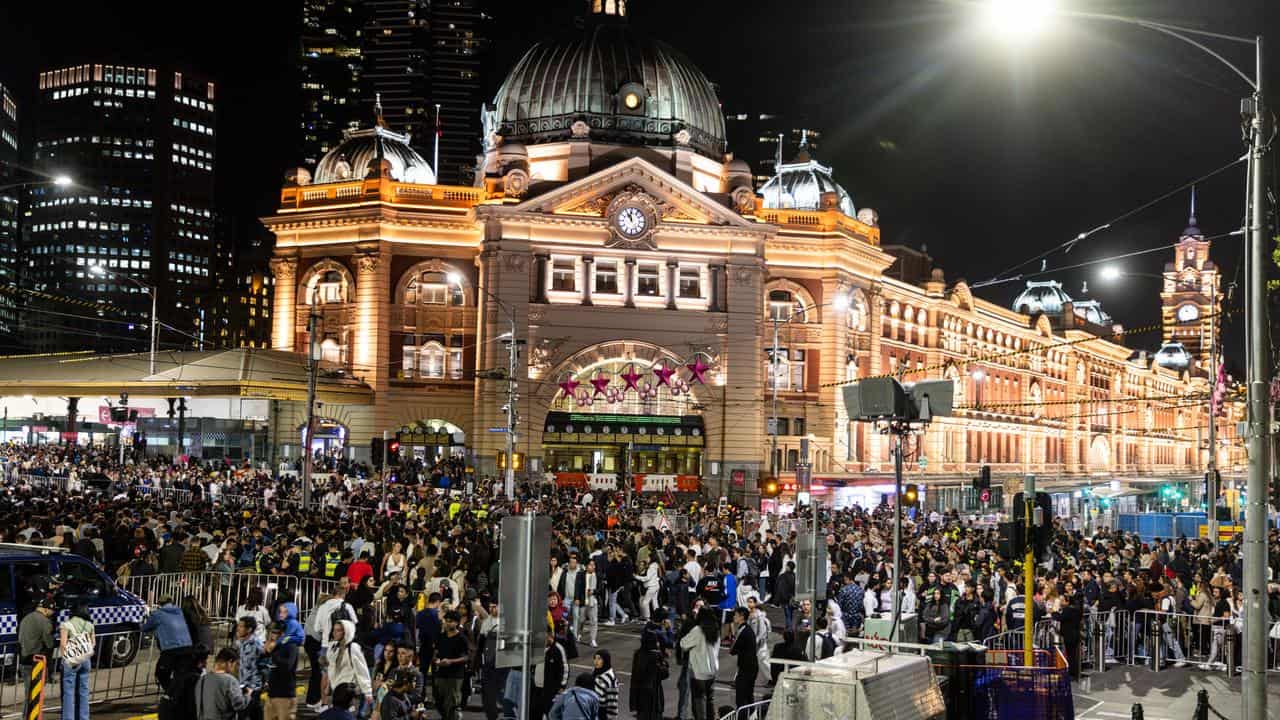 People walk along St Kilda Road on New Year’s Eve in Melbourne