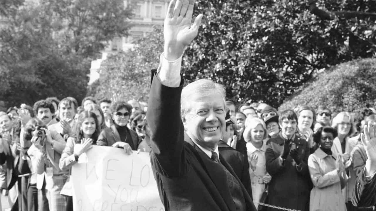 US President Jimmy Carter walks to helicopter for trip to Camp David.