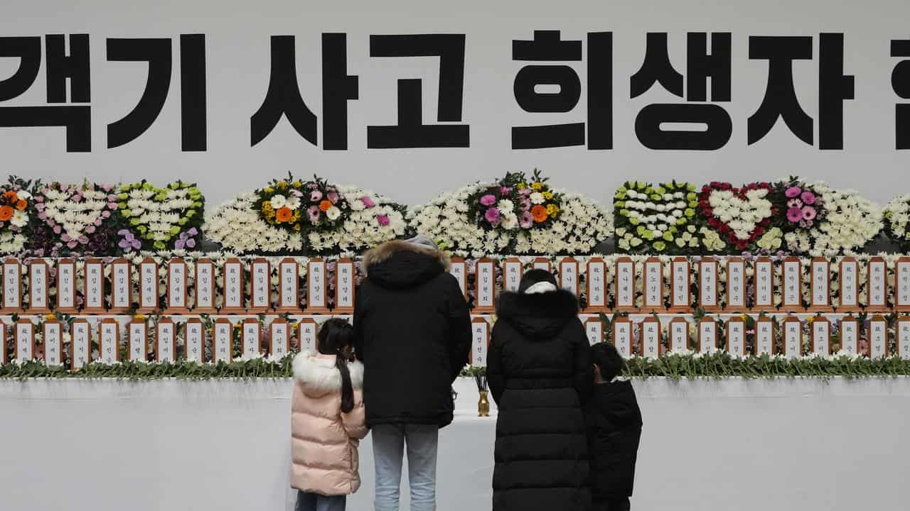 Mourners at a plane crash memorial at Muan sport park, South Korea