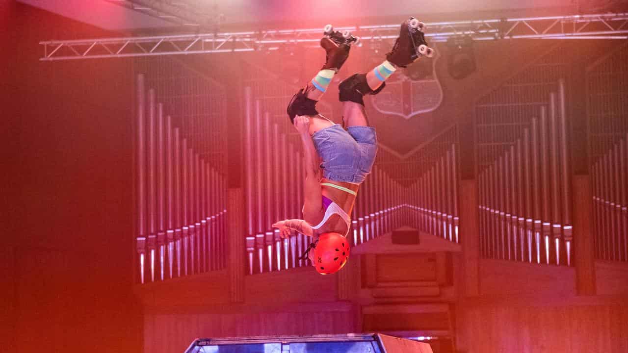 A performer executes a trick on roller skates