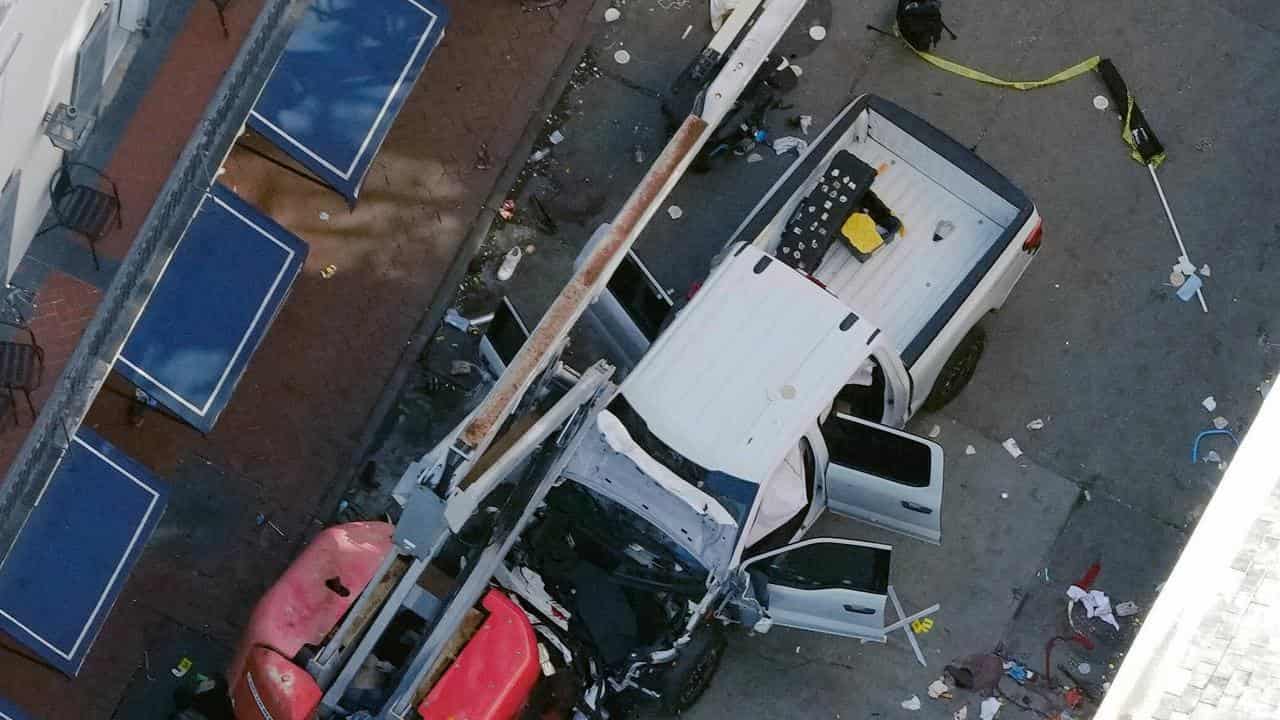 A black flag with white lettering rolled up behind a pick-up truck