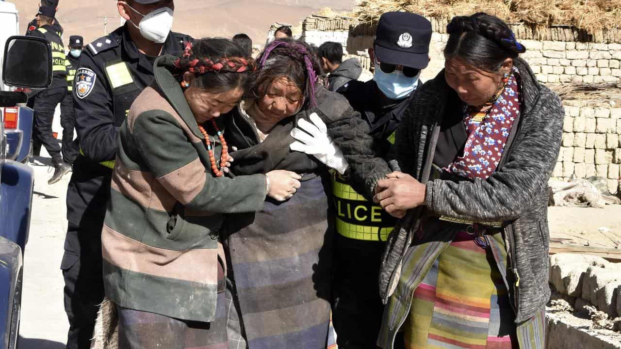 Rescuers with people injured in the Tibet earthquake