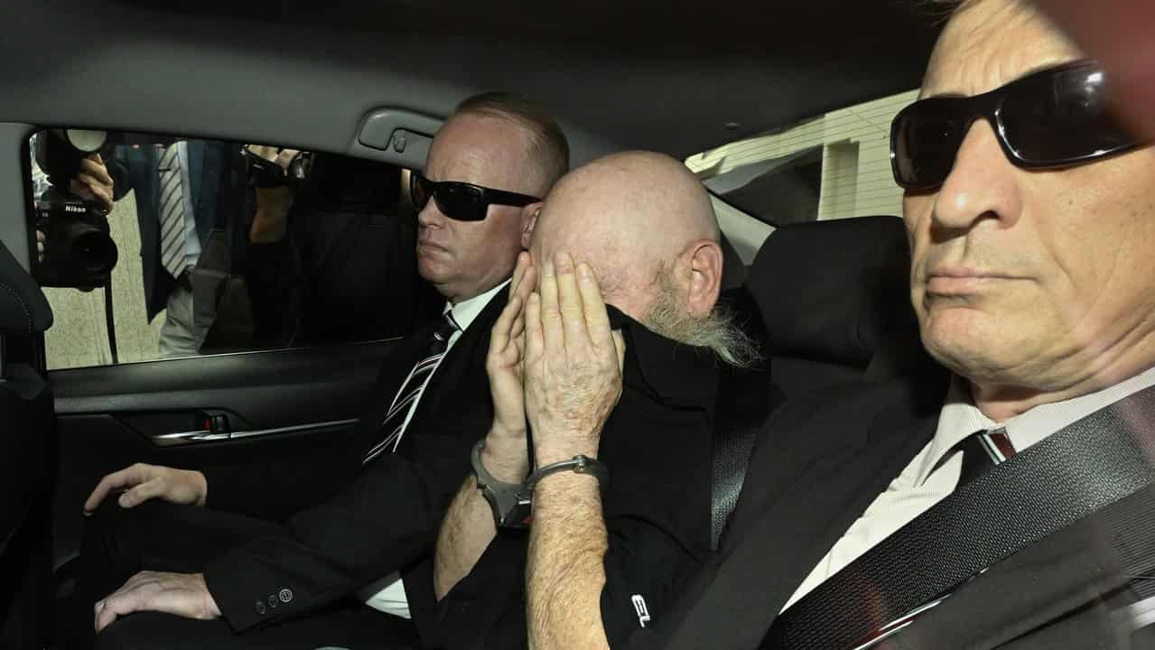 Keith Lees (centre) arrives at the Brisbane Watchhouse