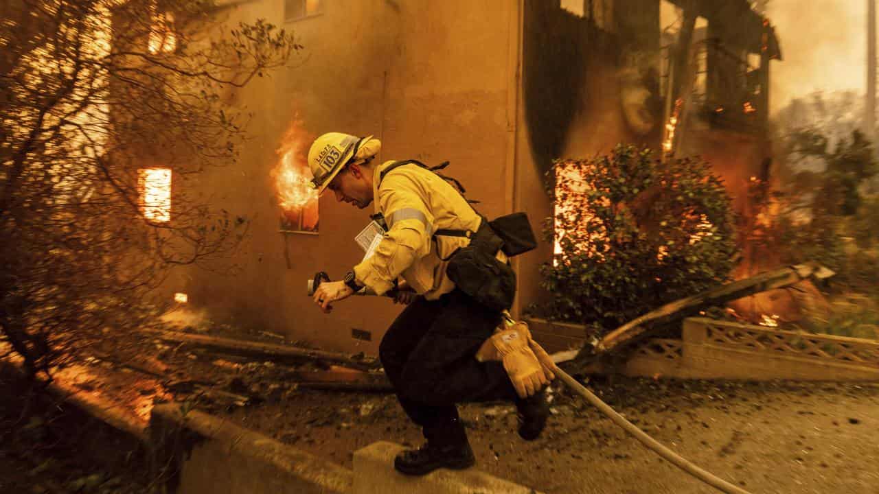 A firefighter battles the Eaton Fire in Altadena, California