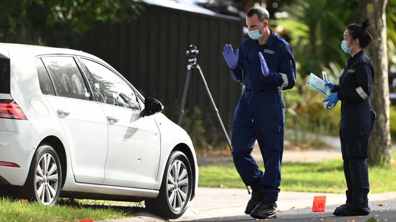 Bullet holes seen in a car as Victoria Police establish a crime scene