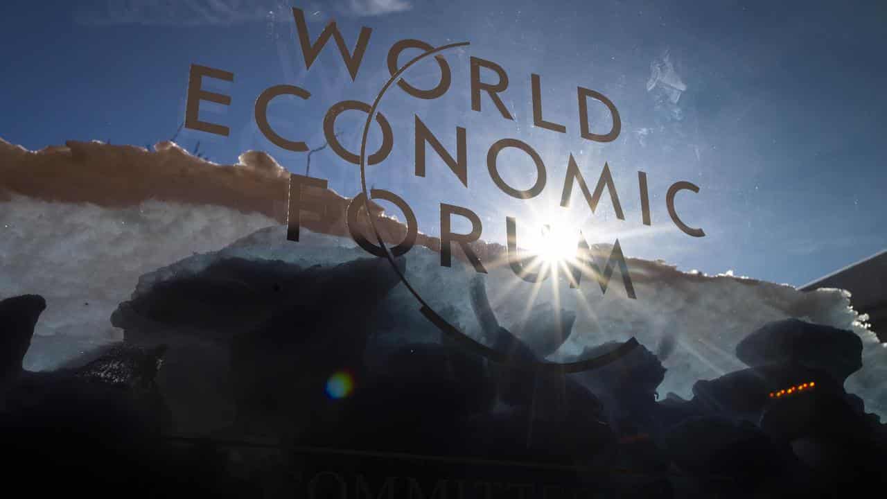 Sun shines through the logo of the  World Economic Forum, Davos