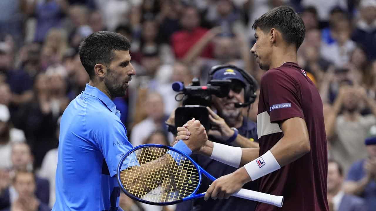 Alexei Popyrin shakes hands with Novak Djokovic.