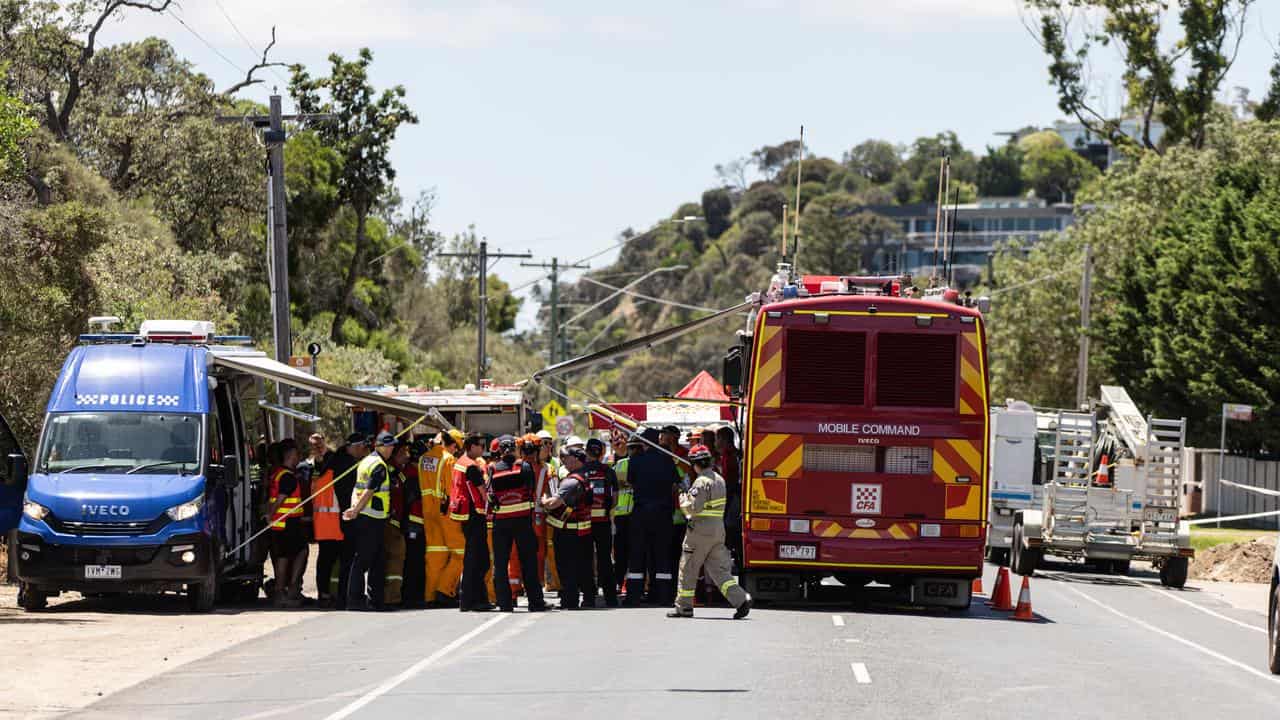 Emergency workers at the scene of a landslide and house collapse