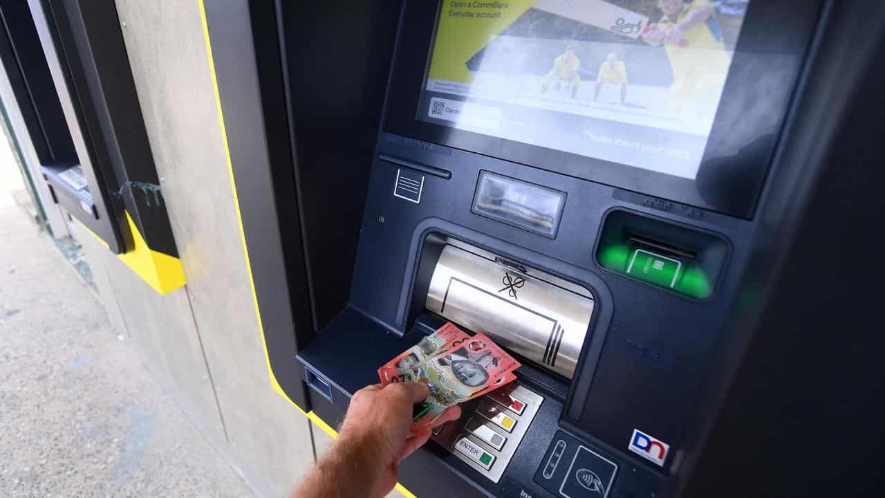 Cash is withdrawn from a Commonwealth Bank ATM.