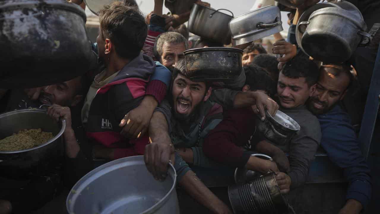 Palestinians struggle for food at a distribution centre in Khan Younis