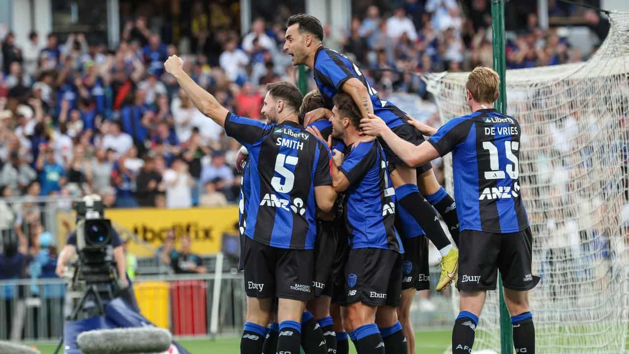 Auckland players celebrate a goal.