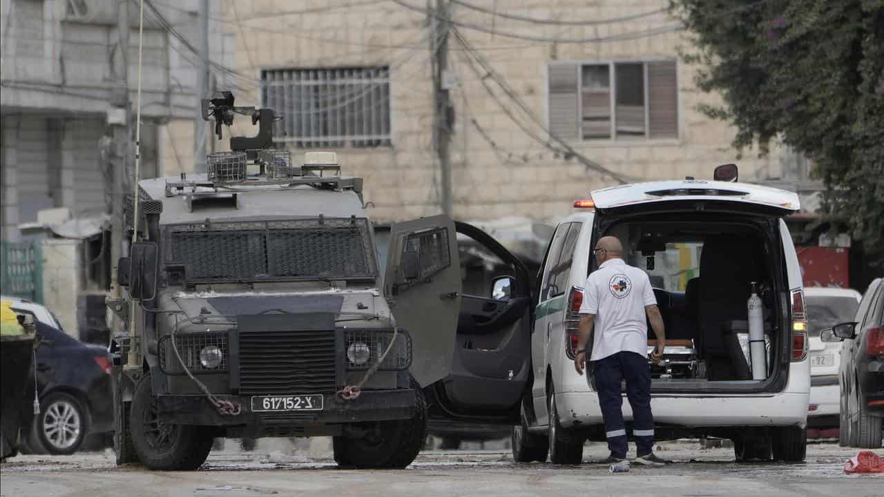 Israeli forces check inside an armoured vehicle check an ambulance