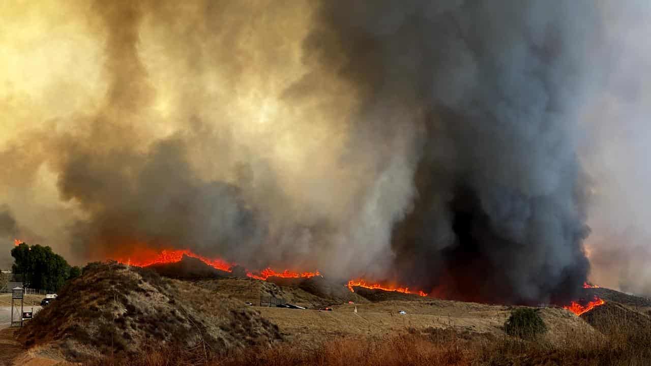 Wildfire burns along a ridge from the Hughes Fire in Castaic