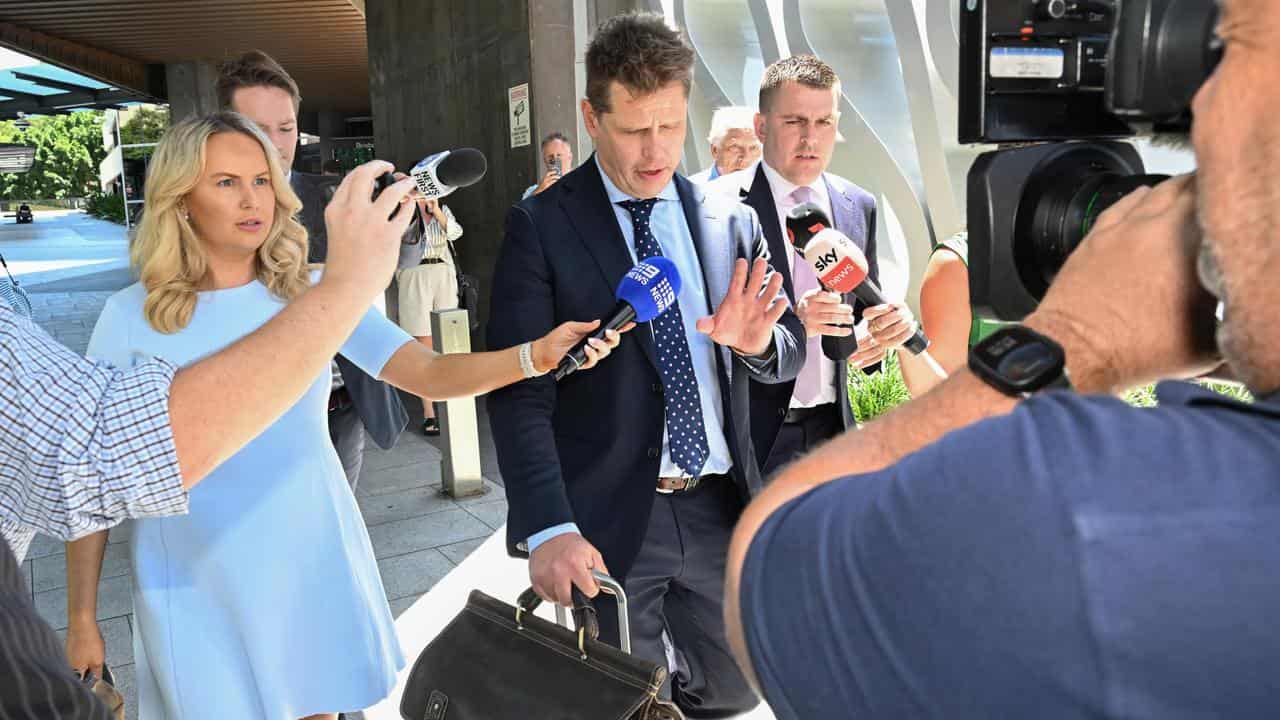 Lawyer Mathew Cuskelly (centre) leaving Brisbane Magistrates Court 