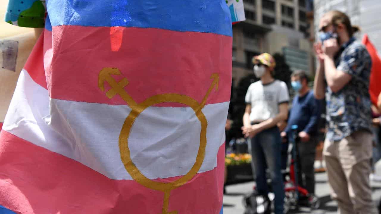 A protester wears a transgender pride flag