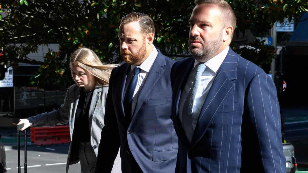 Timothy Rowland (centre) arrives at the Downing Centre District Court