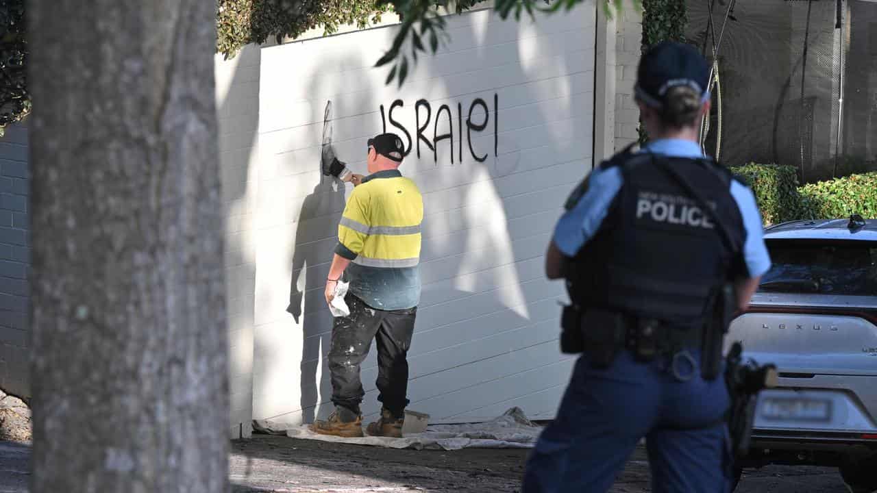 A contractor cleans anti Israel graffiti.