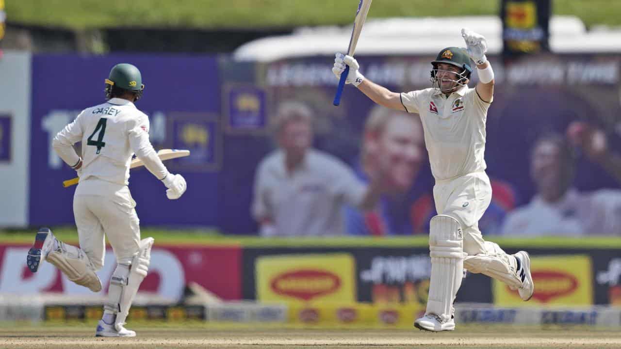 Josh Inglis raises his arms after reaching his century.