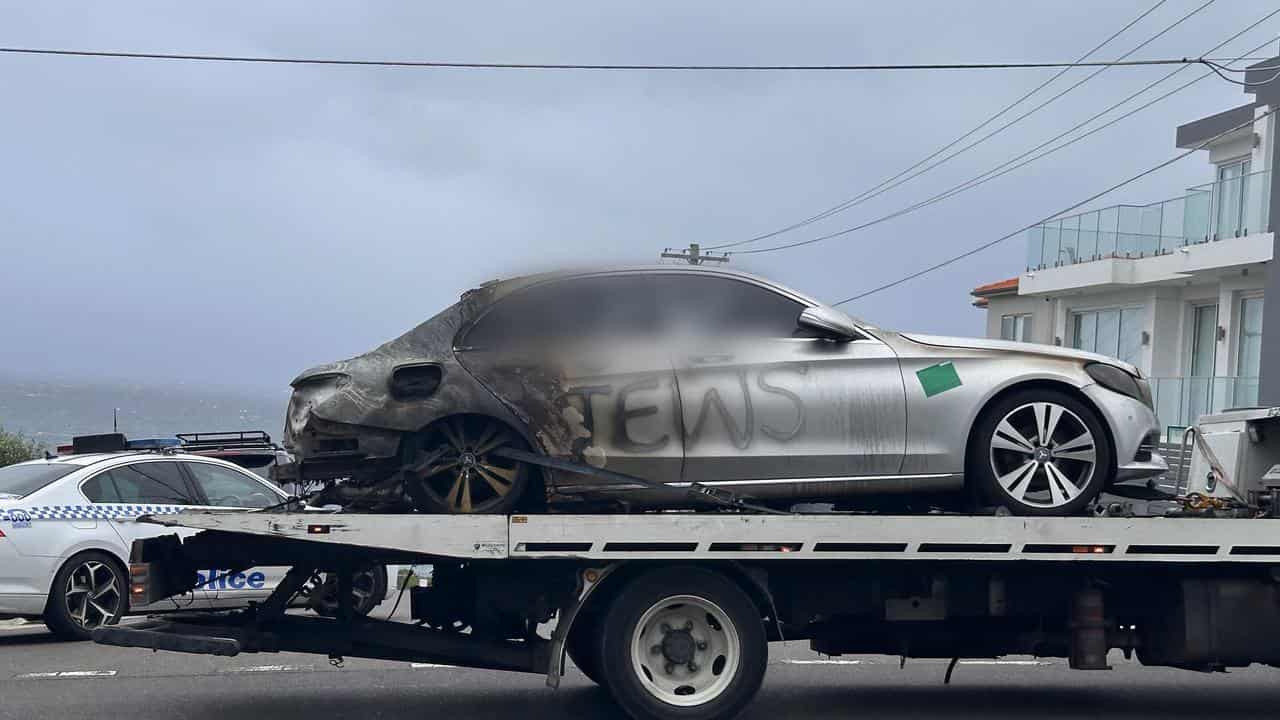 A burnt out car with anti-Semitic graffiti