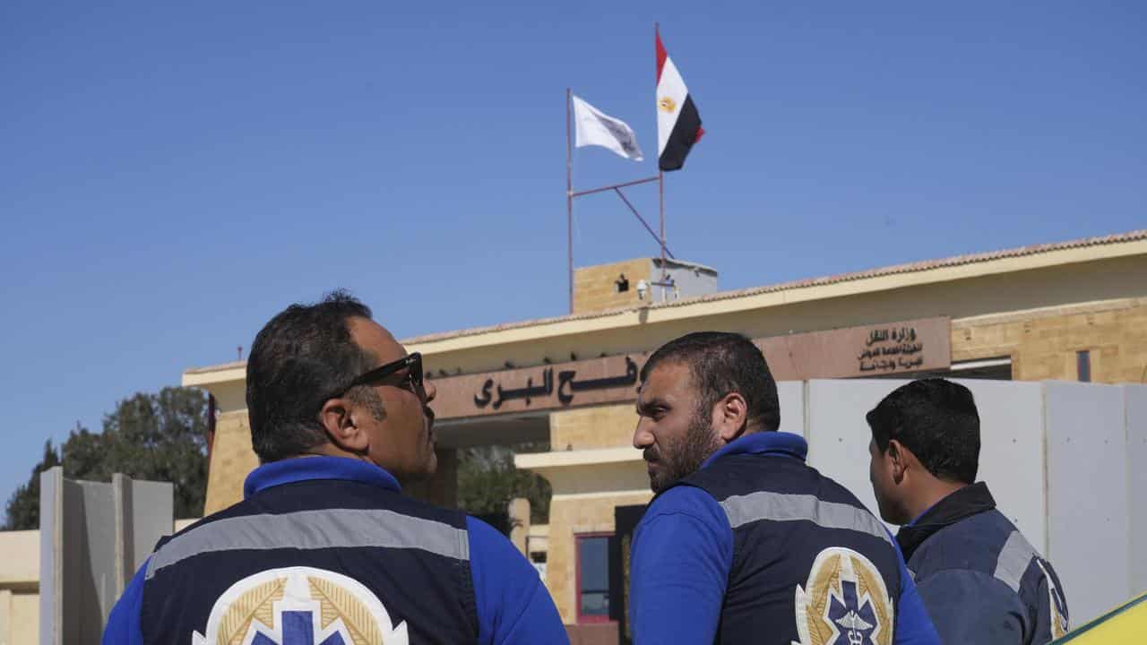 Ambulance workers wait for patients at the Rafah crossing