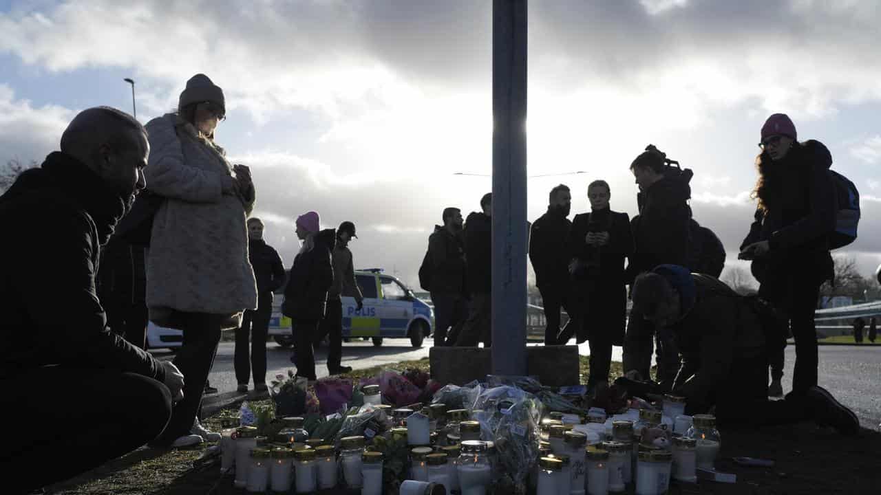 People gather at a makeshift memorial