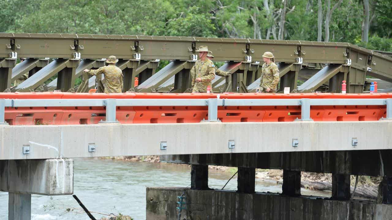 ADF personnel setting up a temporary river crossing .