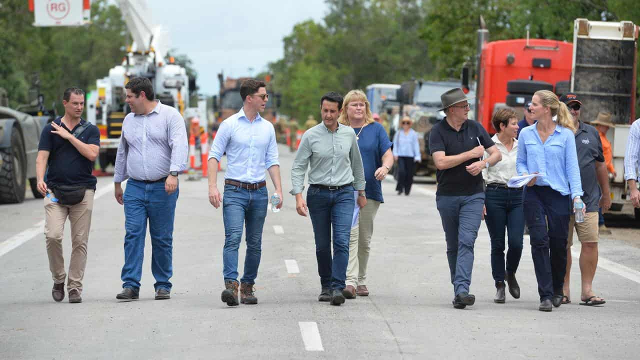 Nine people including the prime minister inspect a highway.