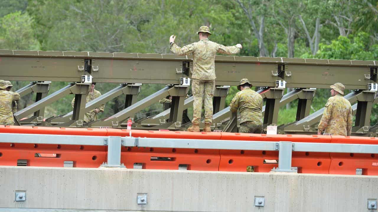 ADF personnel work to repair flood damage at the Ollera Creek bridge