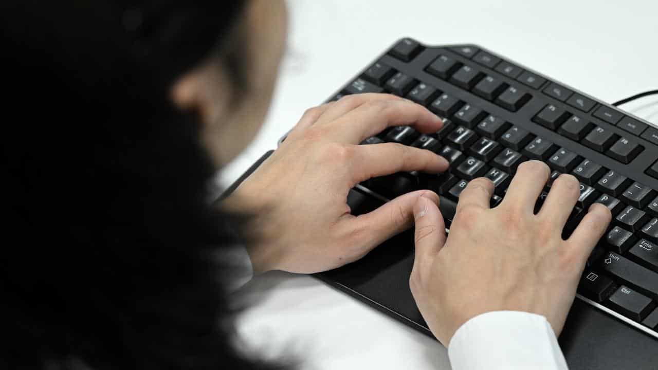 A  person typing on a keyboard (file image)