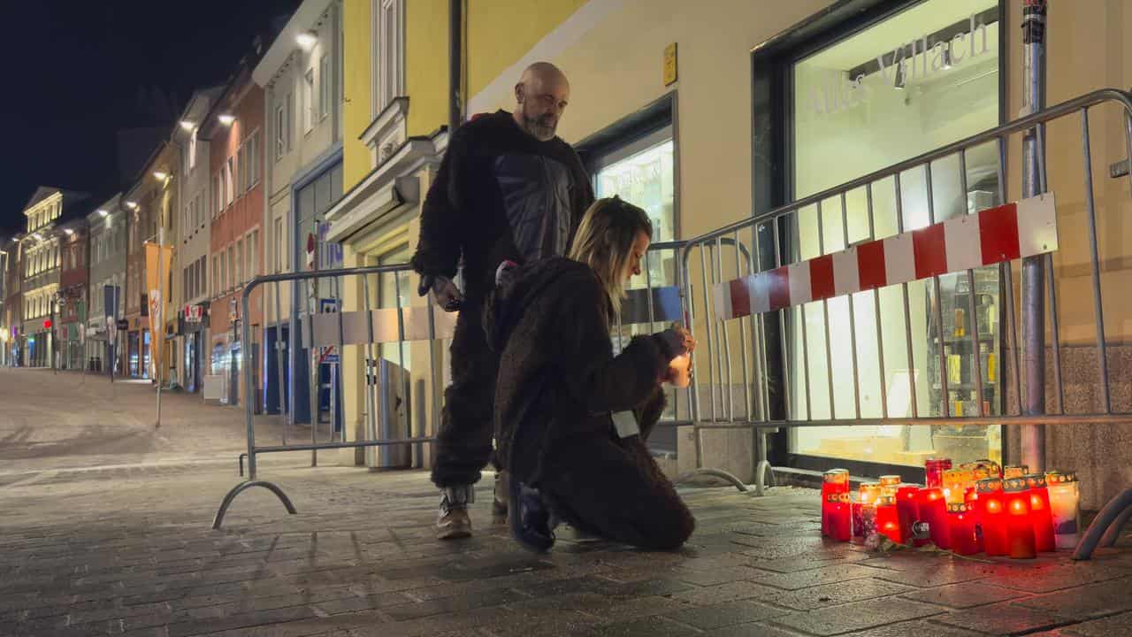 Mourners light candles