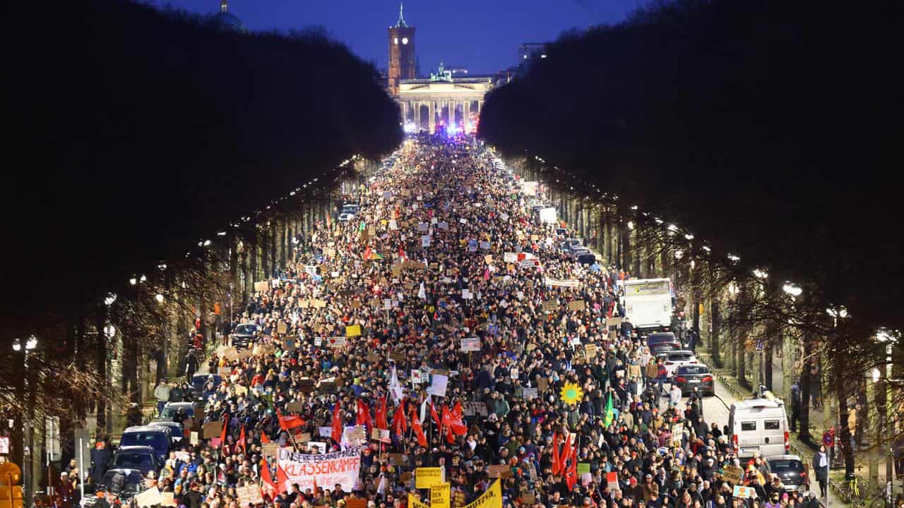 Protesters attend a rally in front of the Brandenburg Gate in Berlin