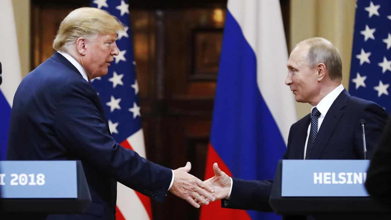 Donald Trump shakes hand with Vladimir Putin