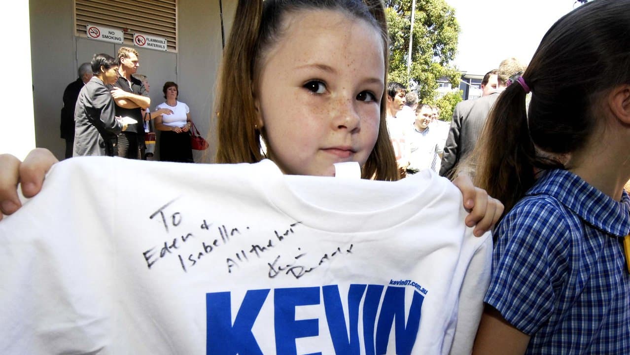A girl displays a T shirt autographed by Kevin Rudd.