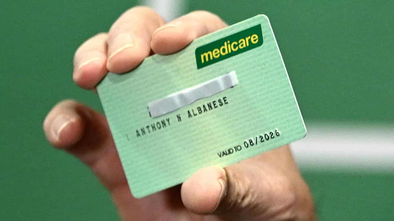 Prime Minister Anthony Albanese holds a Medicare Card