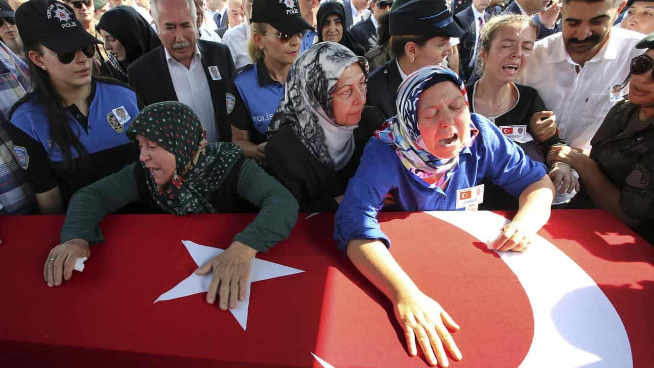 Relatives mourn a Turkish police officer killed in an attack by PKK