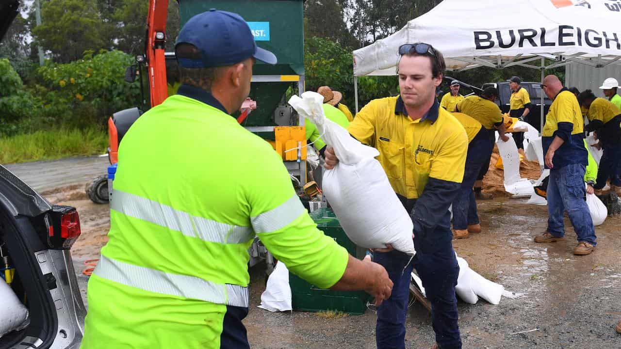 Council workers help residents collect sandbags on the Gold Coast