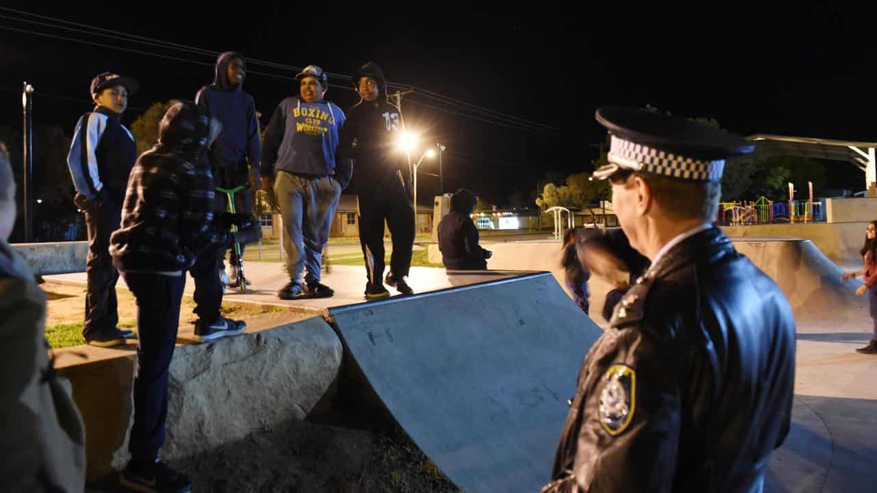 Police officers talk to aboriginal youths in Bourke