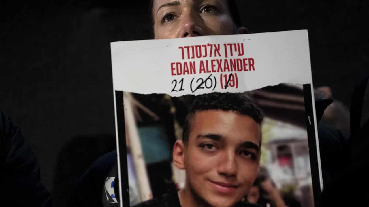 Yael Alexander holds a poster of her son Edan (file image)