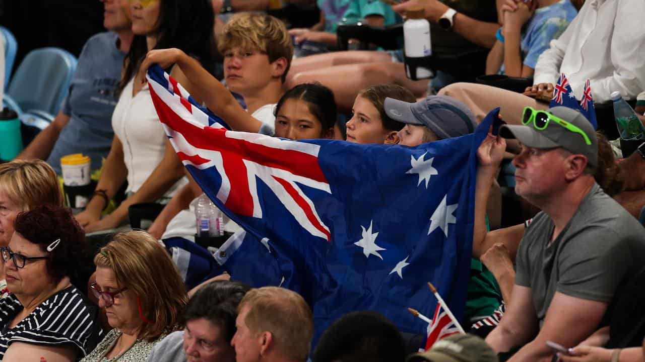 Fans hold up an Australian flag