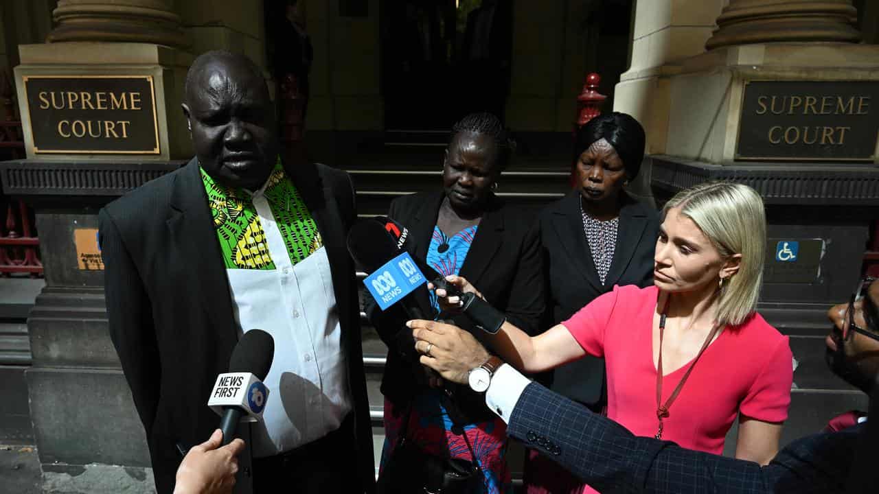 James Riak (left) and Elizabeth Malek (2nd left) speaking to media