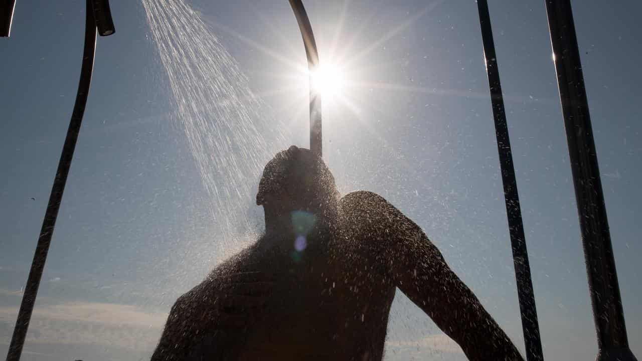 A man showers at Coogee beach in Sydney