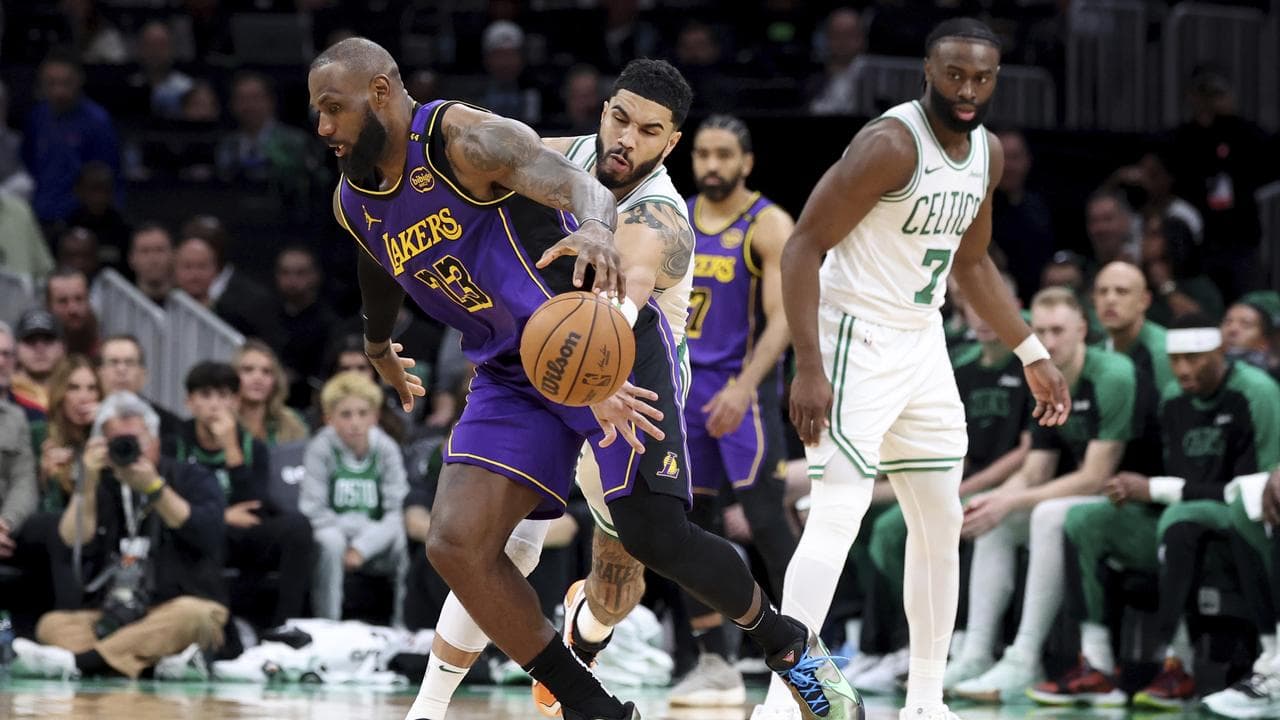 Jayson Tatum (centre) knocks the ball loose from LeBron James.
