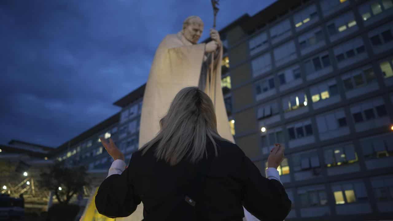 A woman prays for Pope Francis at Agostino Gemelli Polyclinic