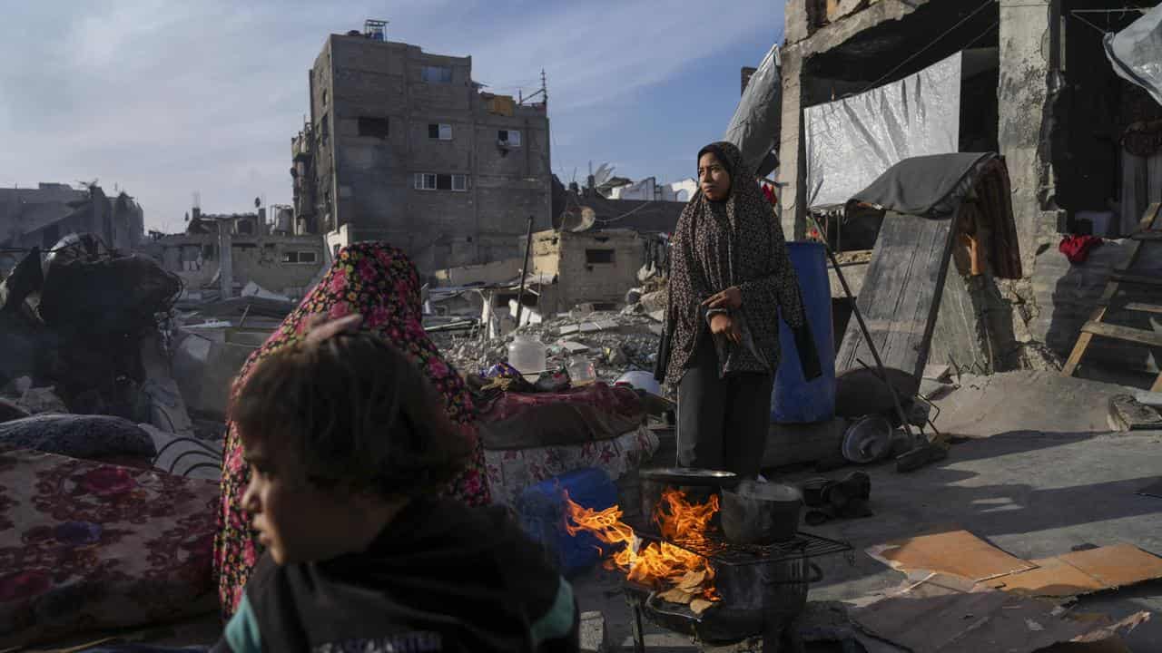 A family cooks outside their destroyed house in Jabaliya, Gaza Strip