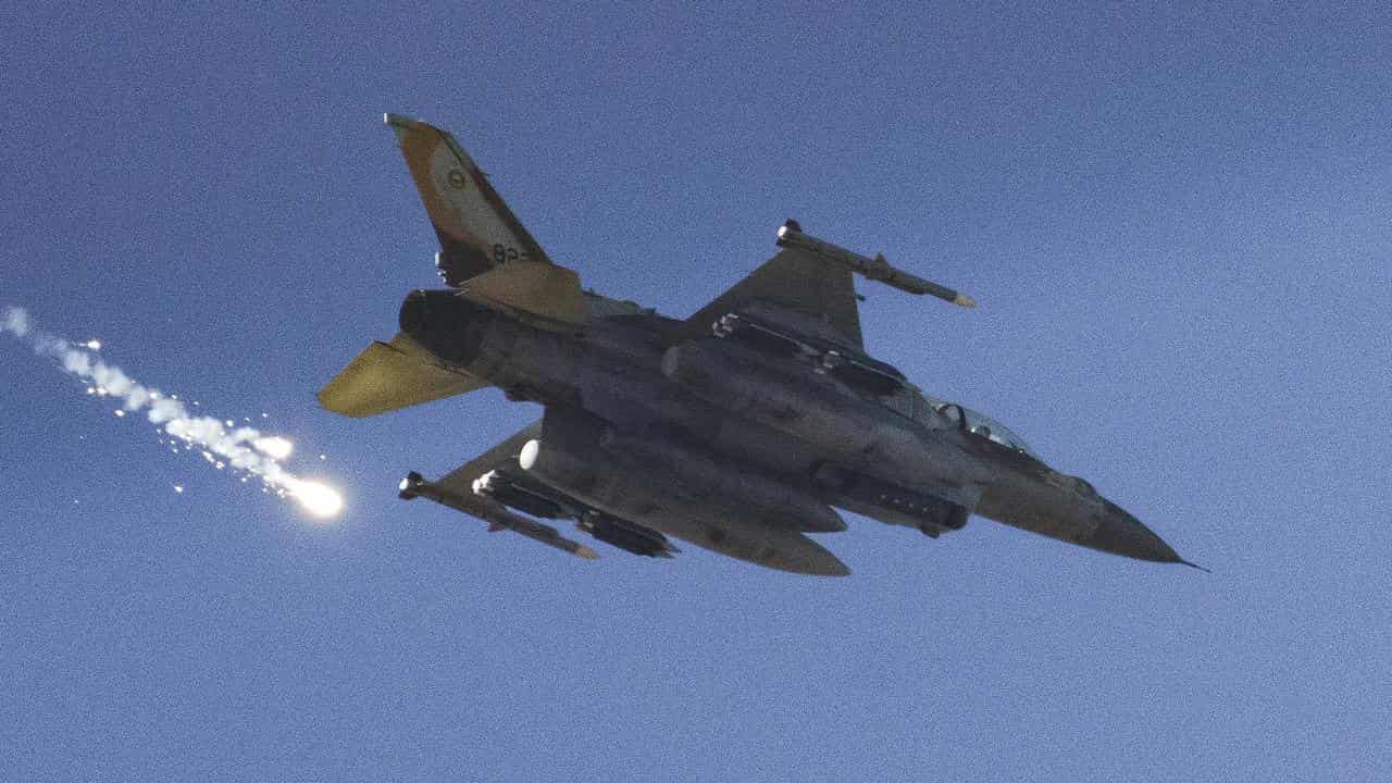 An Israeli fighter jet releases flares as it flies over the Gaza Strip