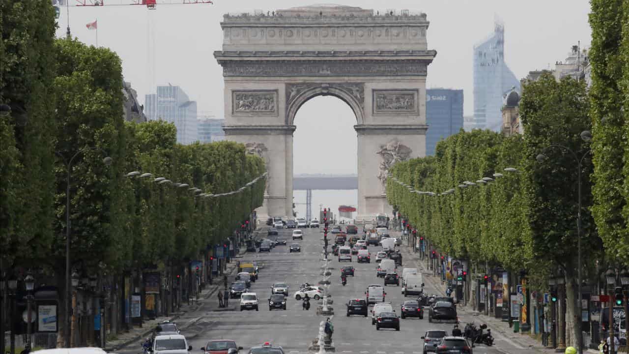 Cars drive on the Champs Elysee avenue